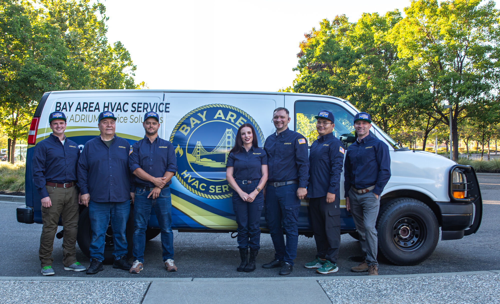 The ADRIUM Service Solutions crew in uniform in front of the Bay Area HVAC Service van