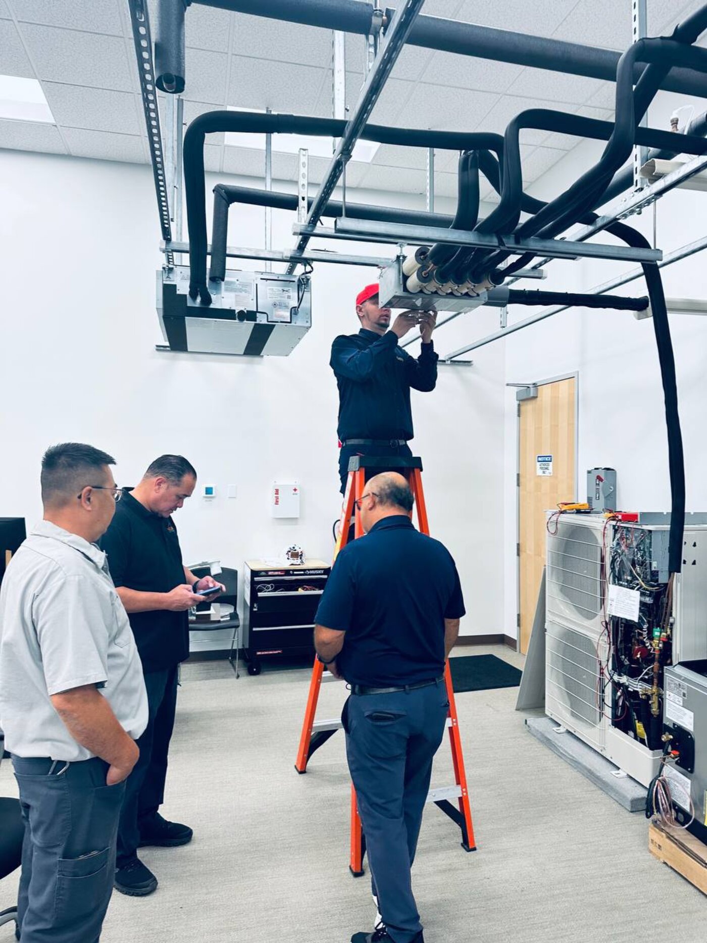 Mitsubishi M- and P-Series service training in progress on a ceiling cassette at the Los Angeles factory training center