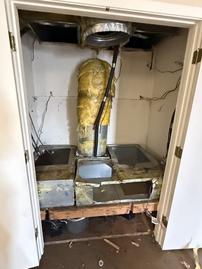Utility closet with old air handlers removed mid-swap during dual Goodman heat pump installation, Morgan Hill