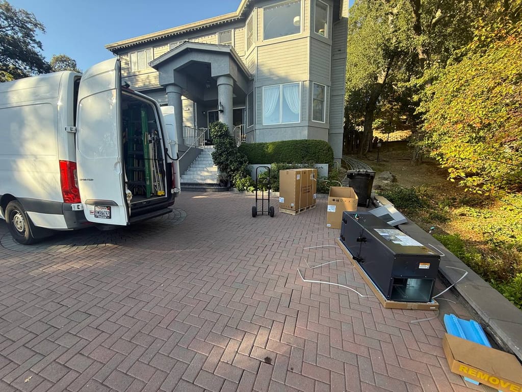 Van and equipment staged in driveway during Bryant heat pump install, Pleasanton