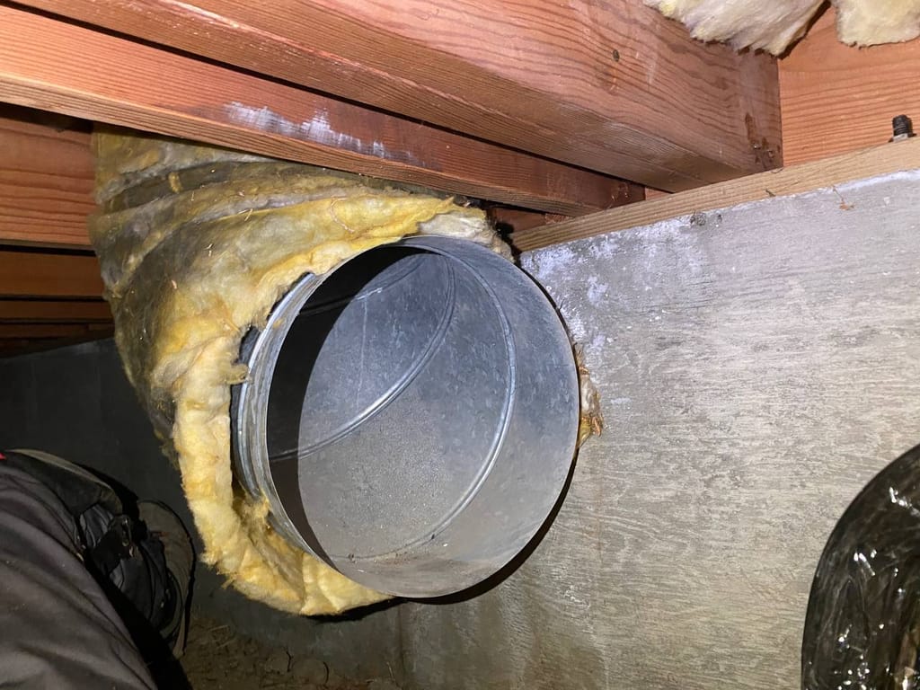 Bare duct collar with torn insulation jacket at a failed crawl-space joint before sealing, Walnut Creek