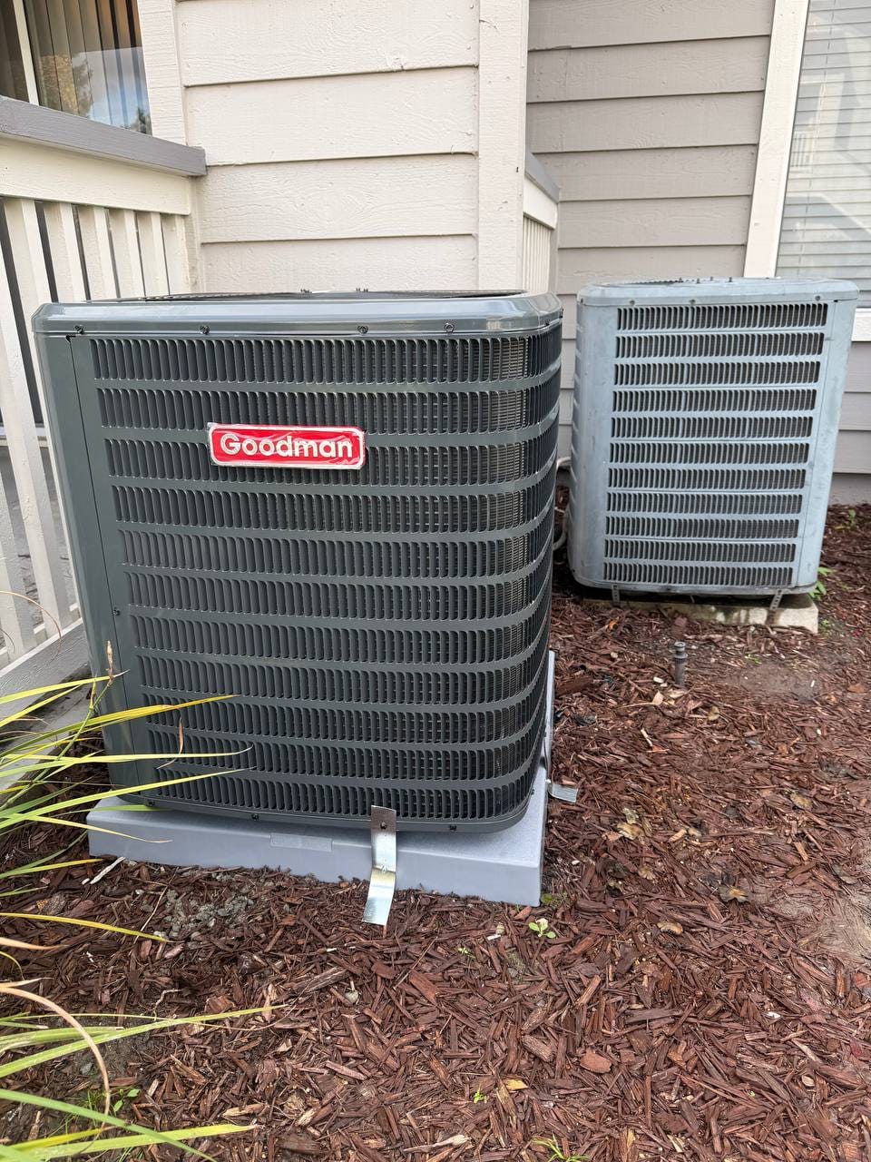 New Goodman heat pump condenser set beside the old outdoor unit, San Ramon