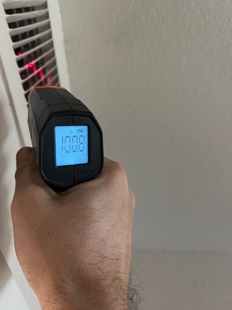 Infrared thermometer checking supply register temperature at startup, San Ramon