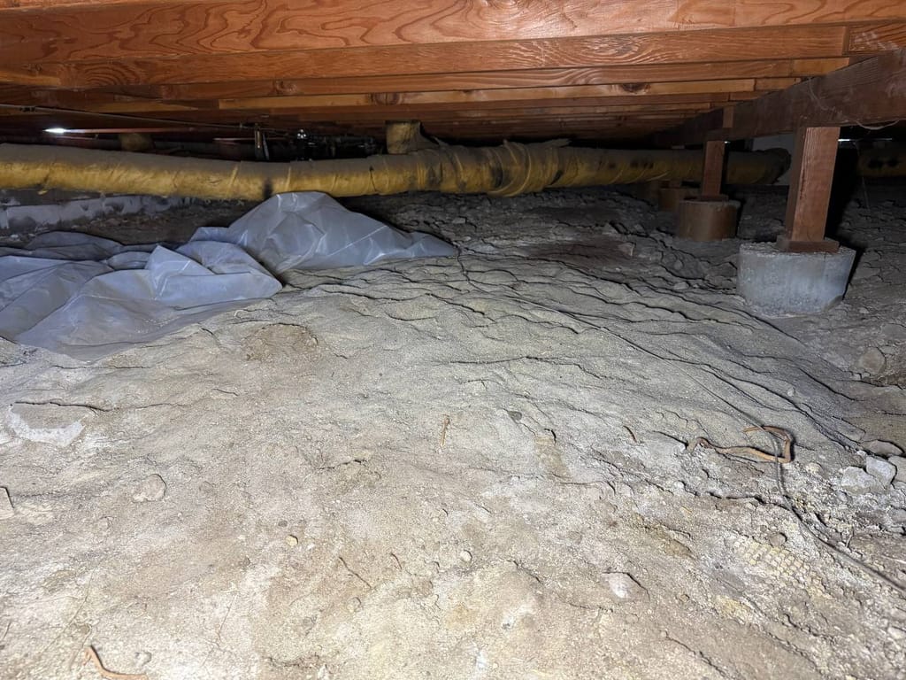 Crawl space under the house showing existing insulated ductwork before heat pump work, Martinez