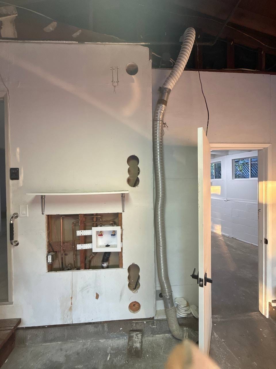 Flexible vent duct run and open plumbing wall cavity during installation, Martinez