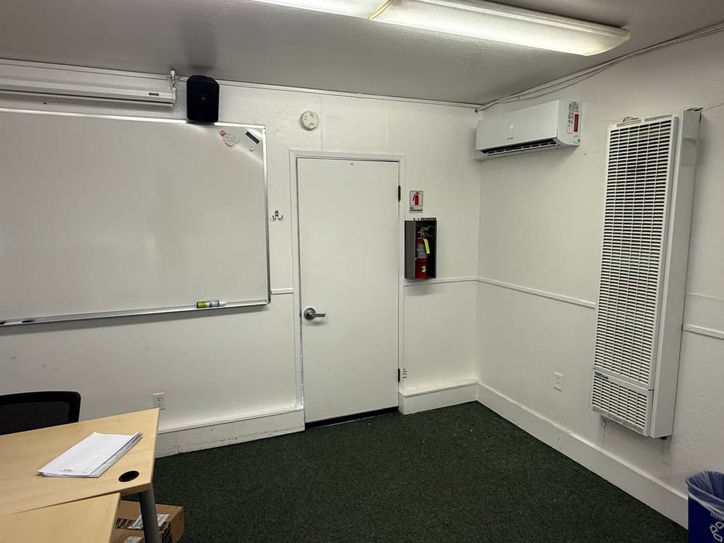 Ductless mini-split indoor unit mounted in a classroom next to the old wall furnace, The Athenian School, Danville