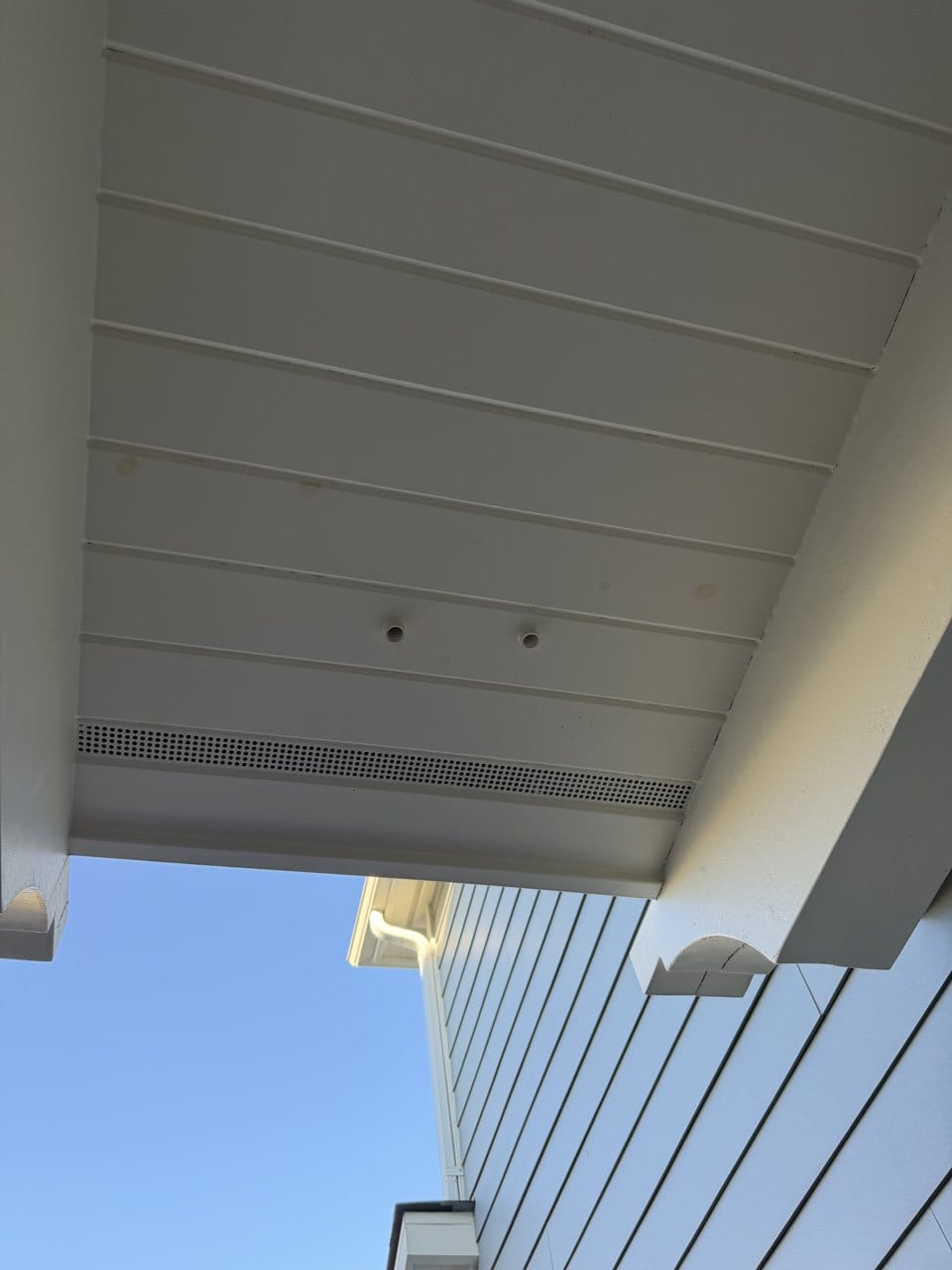 Condensate drain outlets under the carport roof of a San Mateo home