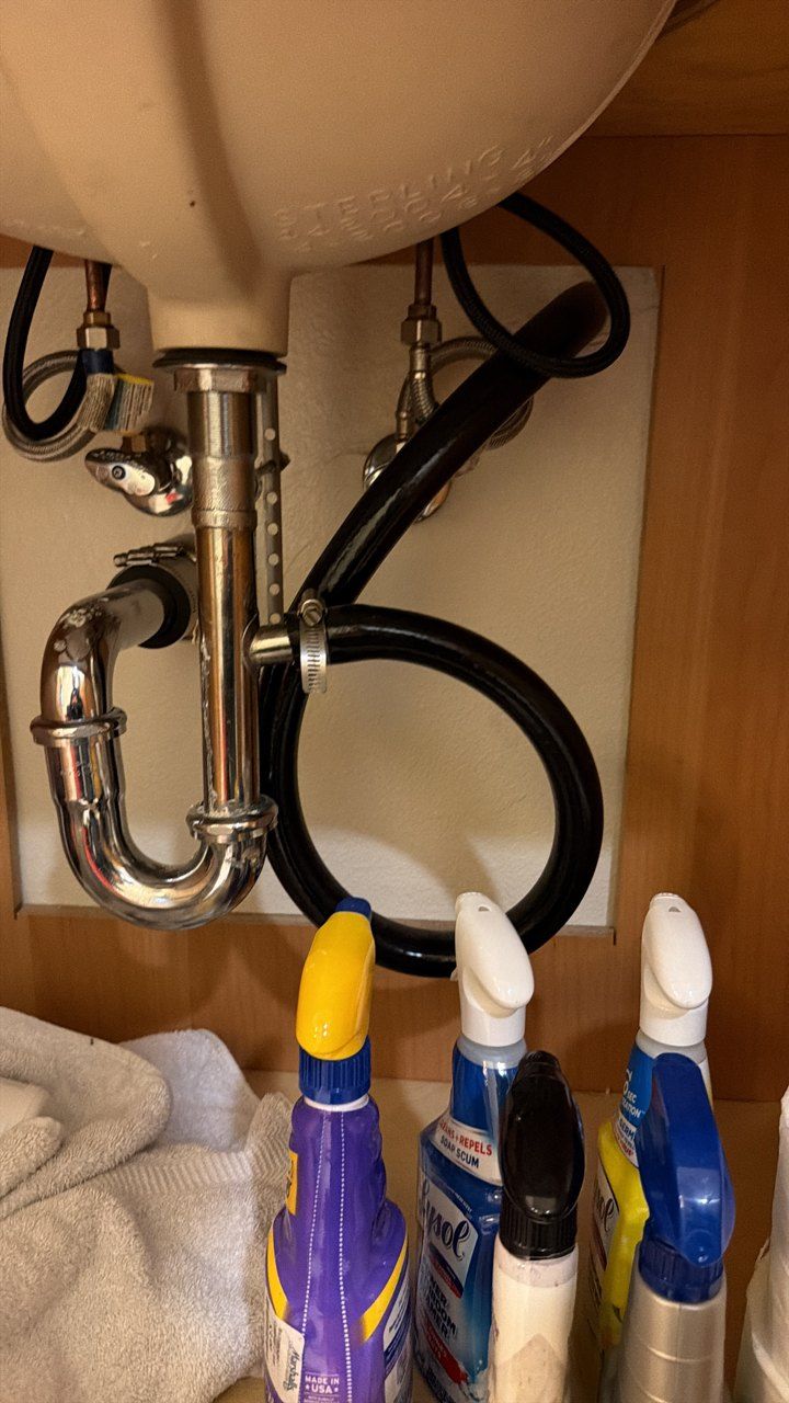 Black condensate hose tied into the drain under the bathroom sink, San Jose