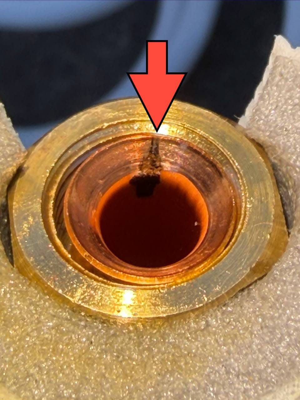 Split across the copper flare sealing face, marked with an arrow