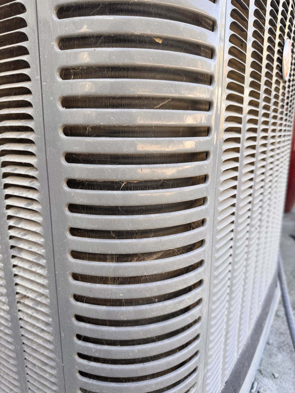 Rheem outdoor AC unit in Clayton, with its coil visible behind the cabinet grille