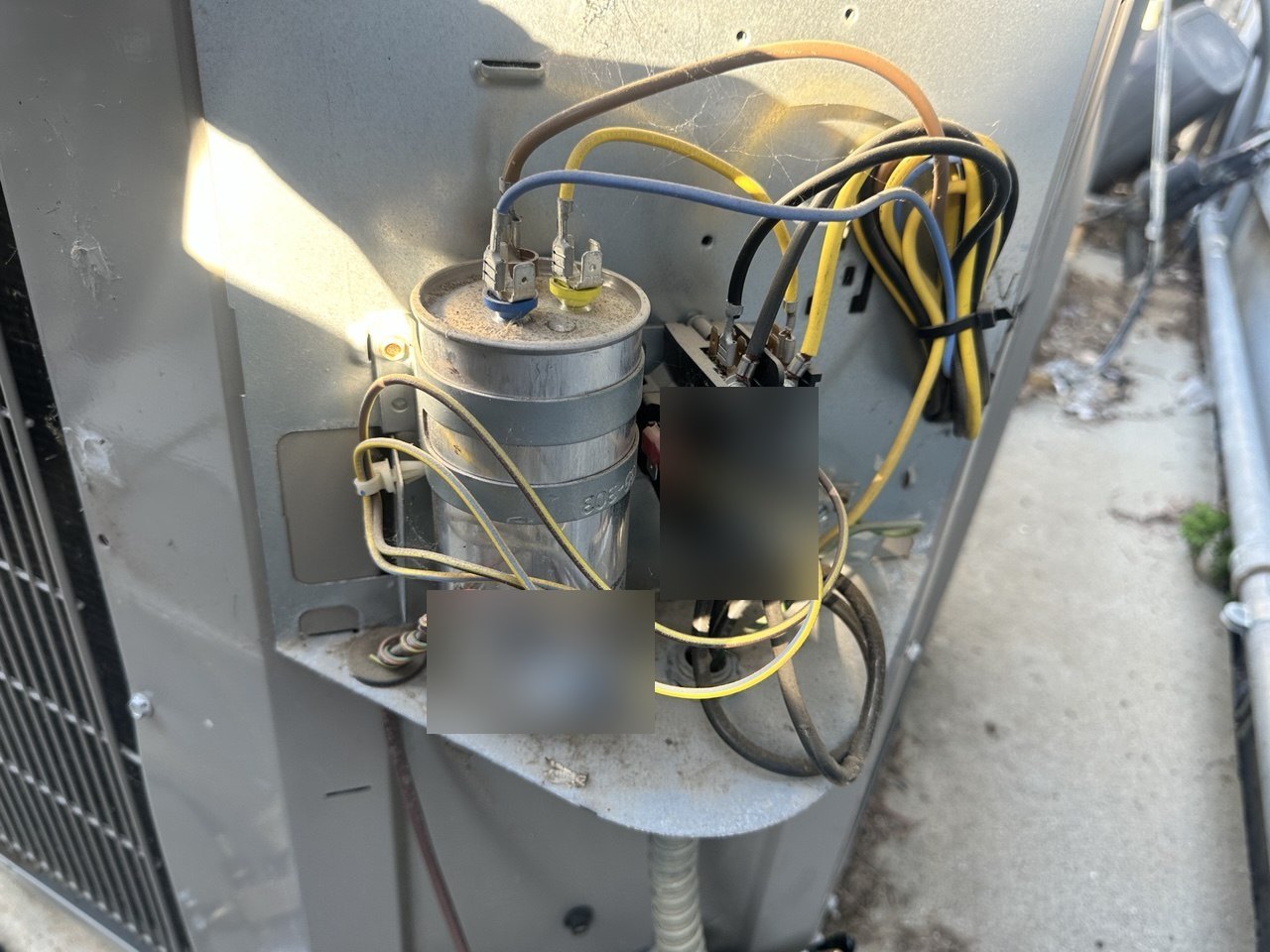 Open outdoor-unit electrical compartment with a wired capacitor during the Los Gatos repair