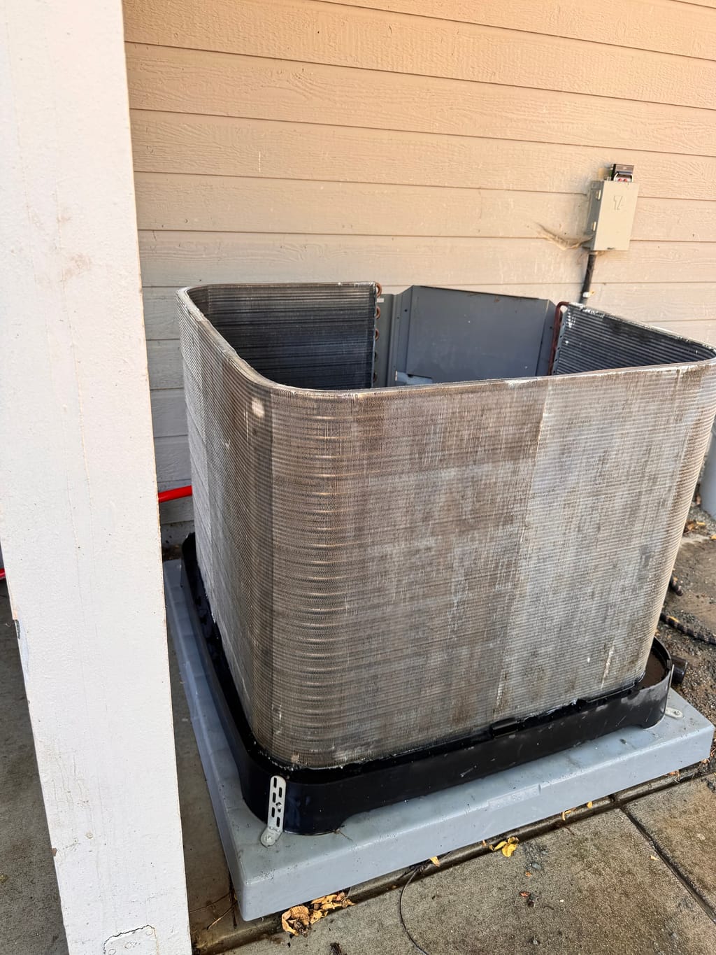 A Rheem outdoor coil beside the beige wall after cleaning in Clayton