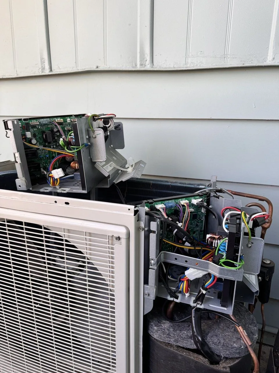 Two Daikin outdoor control boards during the board swap in Concord, CA, one set on top of the unit