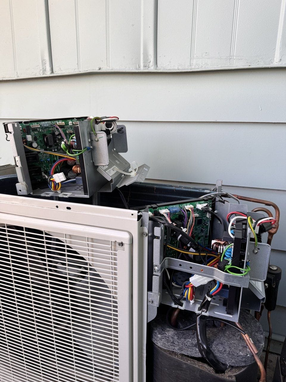 Two Daikin outdoor control boards during the board swap in Concord, CA, one set on top of the unit