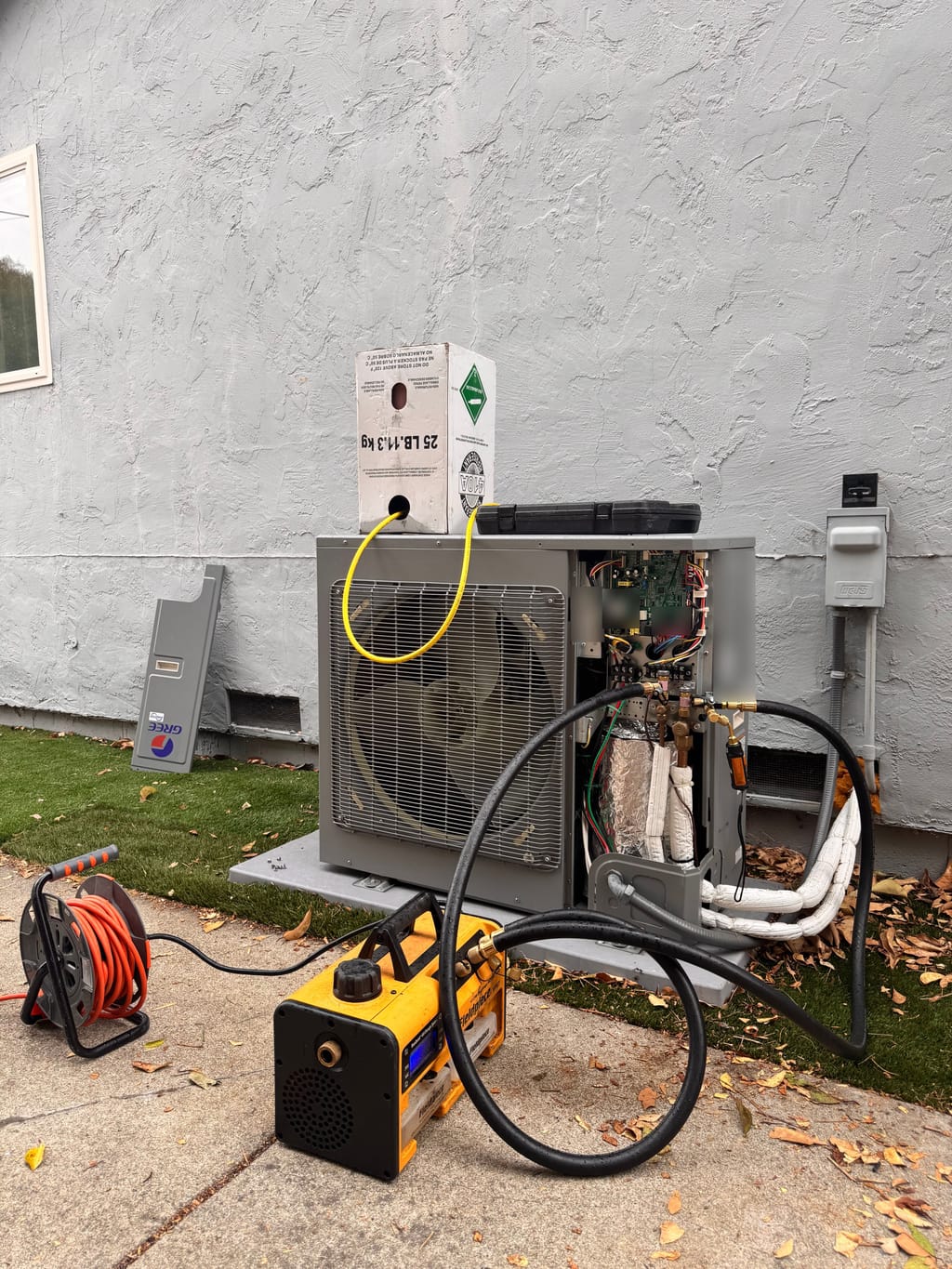 Service hoses connected to the Gree outdoor unit, with an R-410A cylinder above it