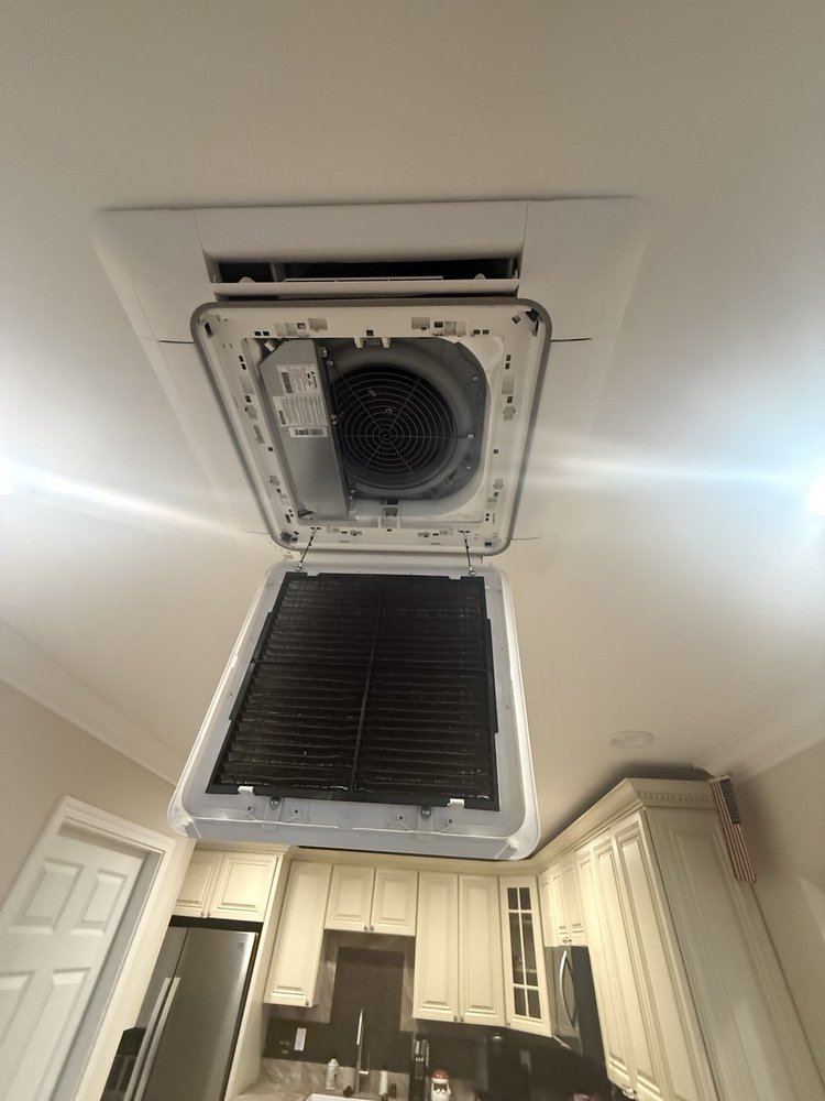 Ductless mini-split ceiling cassette unit opened for service in a residential kitchen