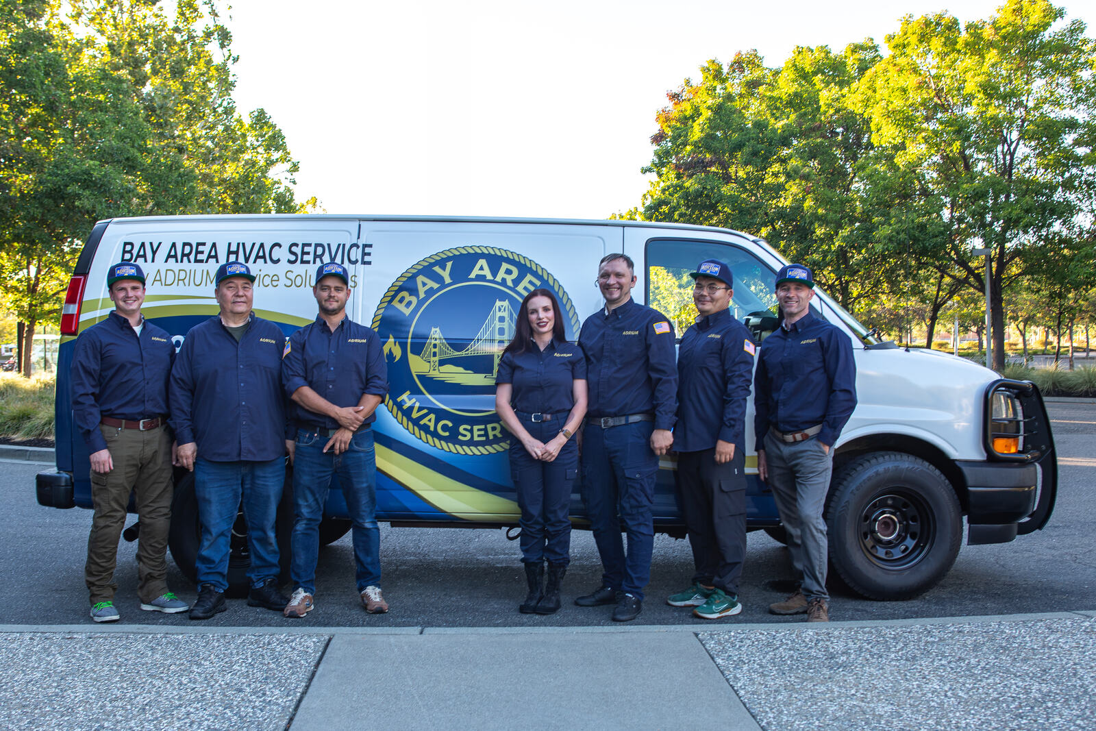 The ADRIUM Service Solutions crew in uniform in front of the Bay Area HVAC Service van